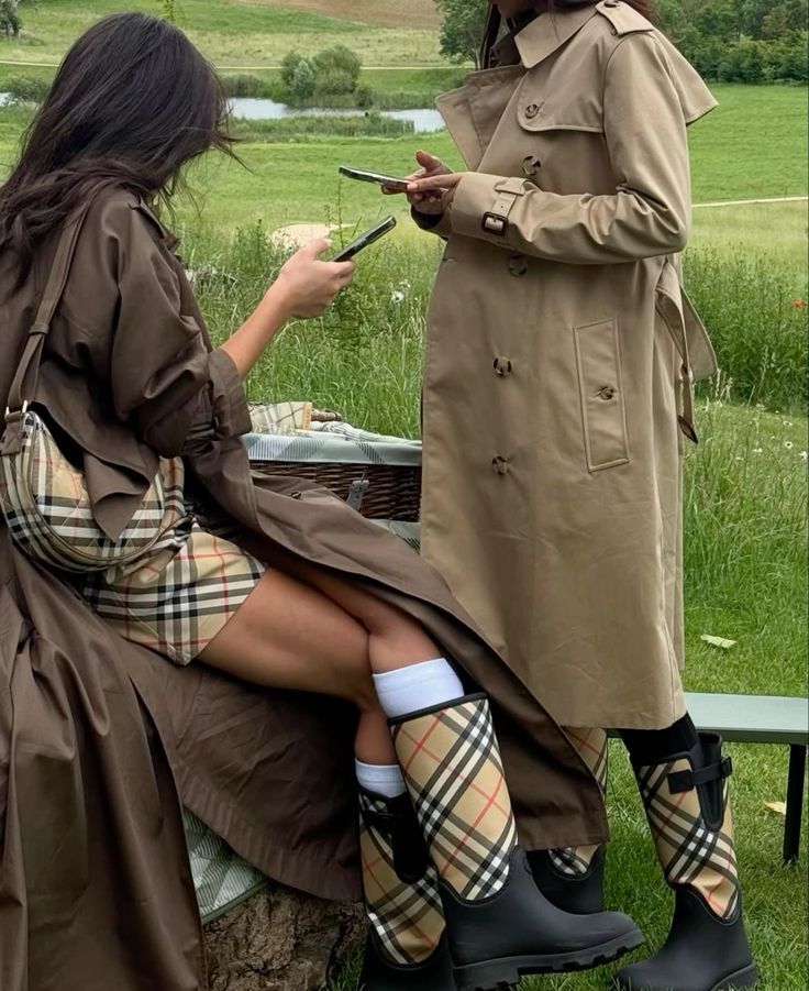 Two women outdoors in trenches and check accessories